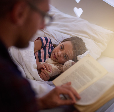 Buy stock photo Shot of a father reading a bedtime story to his daughter