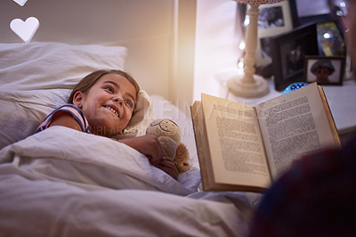 Buy stock photo Shot of a father reading a bedtime story to his daughter