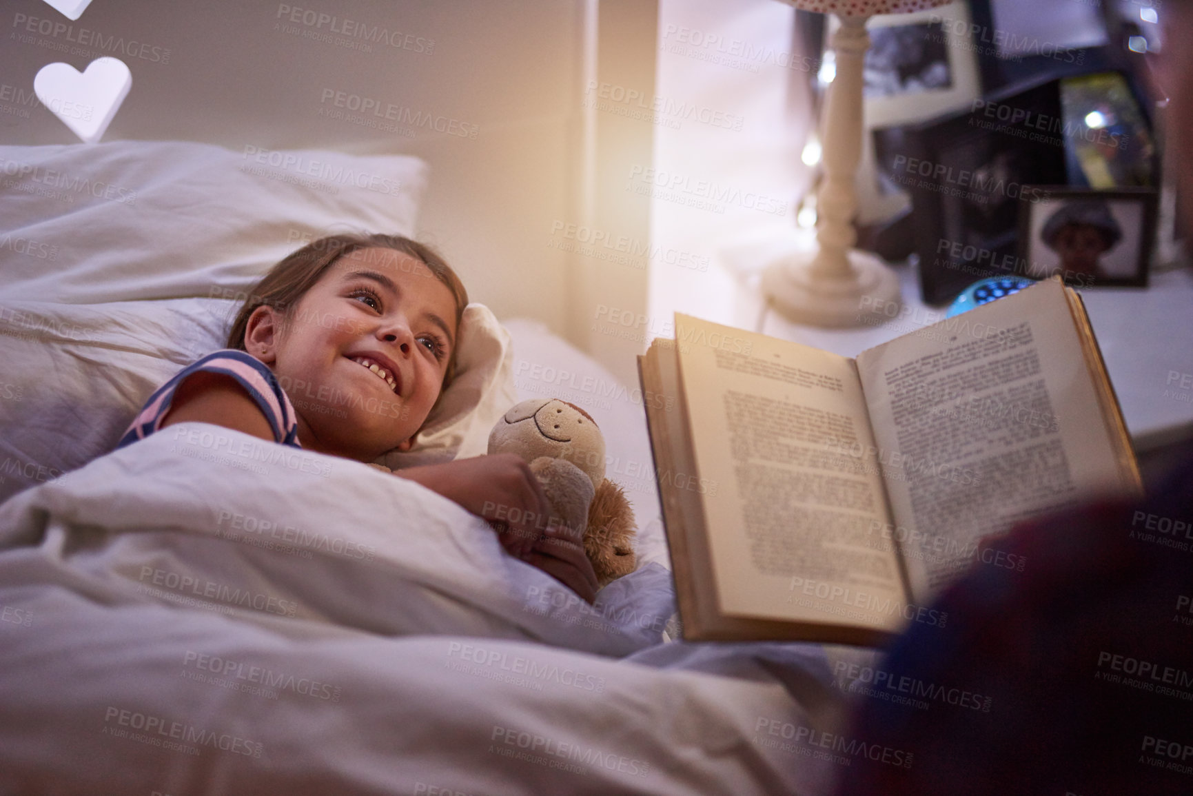 Buy stock photo Shot of a father reading a bedtime story to his daughter