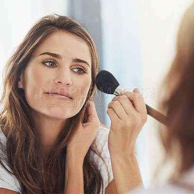 Buy stock photo Shot of a beautiful young woman applying makeup with a brush