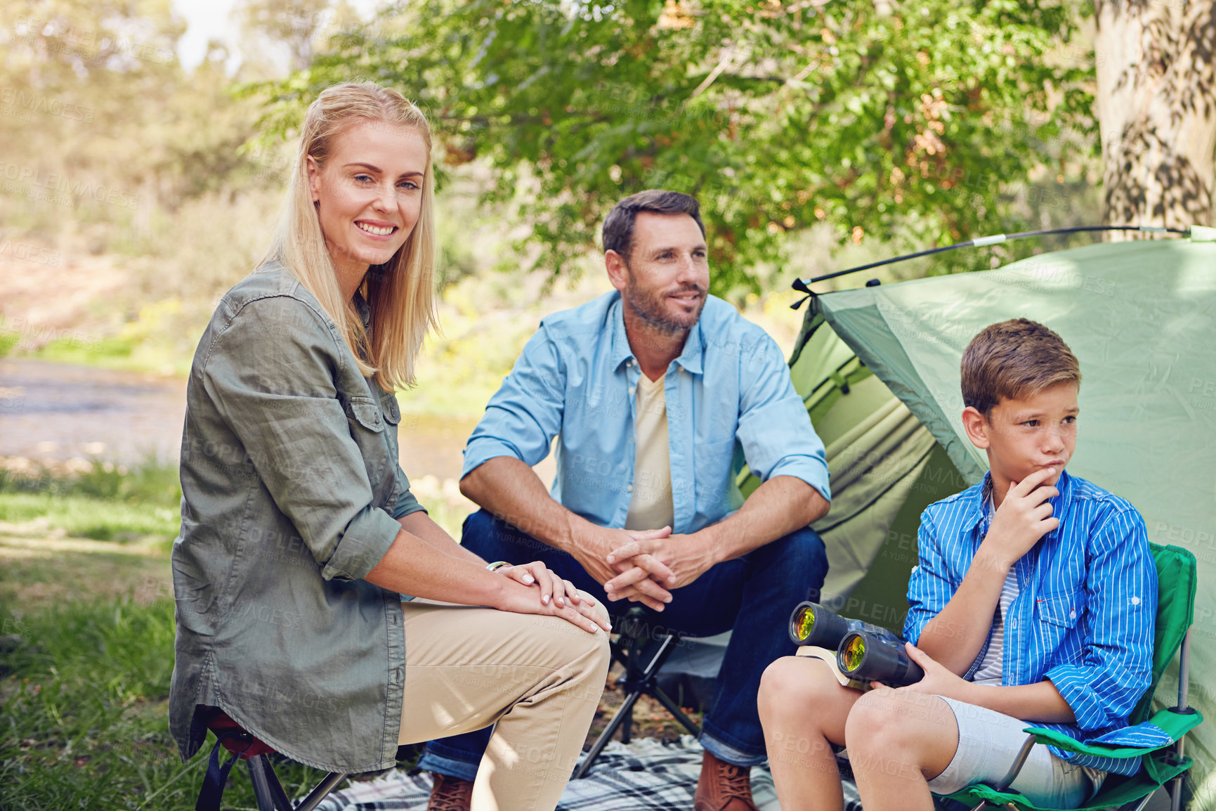 Buy stock photo Cropped shot of a family of three camping in the woods