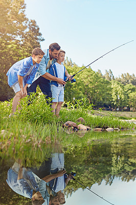 Buy stock photo Shot of a father and his two sons out fishing in the woods