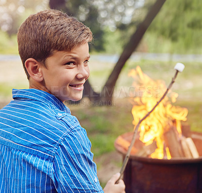 Buy stock photo Shot of a boy roasting marshmallows while camping together