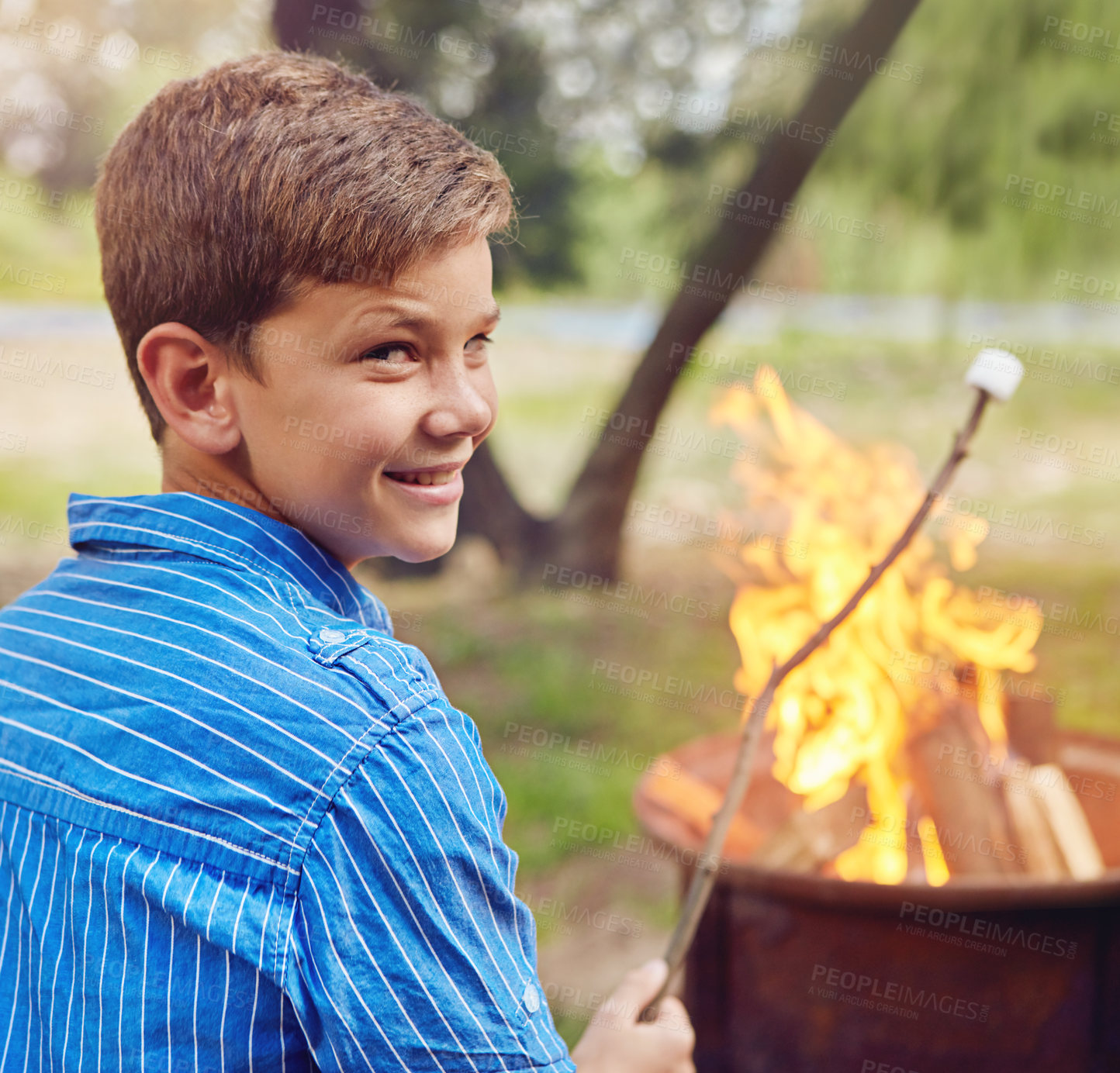 Buy stock photo Shot of a boy roasting marshmallows while camping together