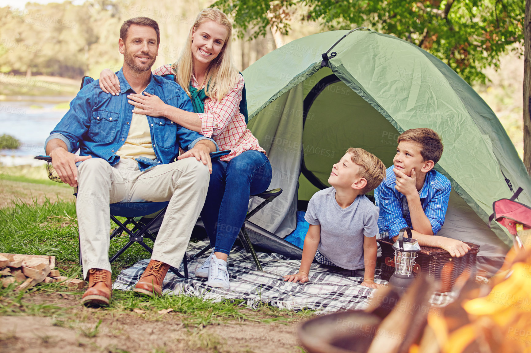 Buy stock photo Shot of a family of four camping in the woods