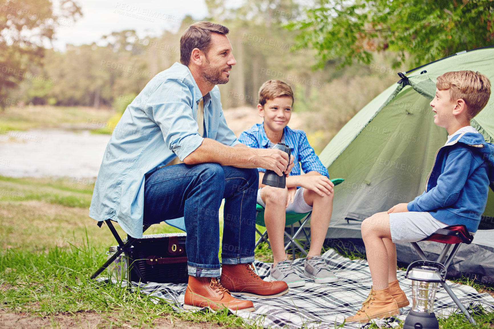 Buy stock photo Shot of a father and his two sons out camping in the woods