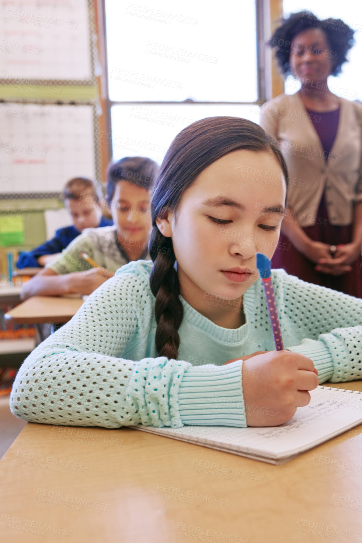 Buy stock photo Shot of a young girl sitting in class with her teacher and classmates blurred in the background