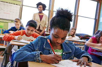 Buy stock photo Children, education and school with a student black girl writing in a book while sitting in class for learning. Study, notebook and scholarship with a female child at her desk in the classroom