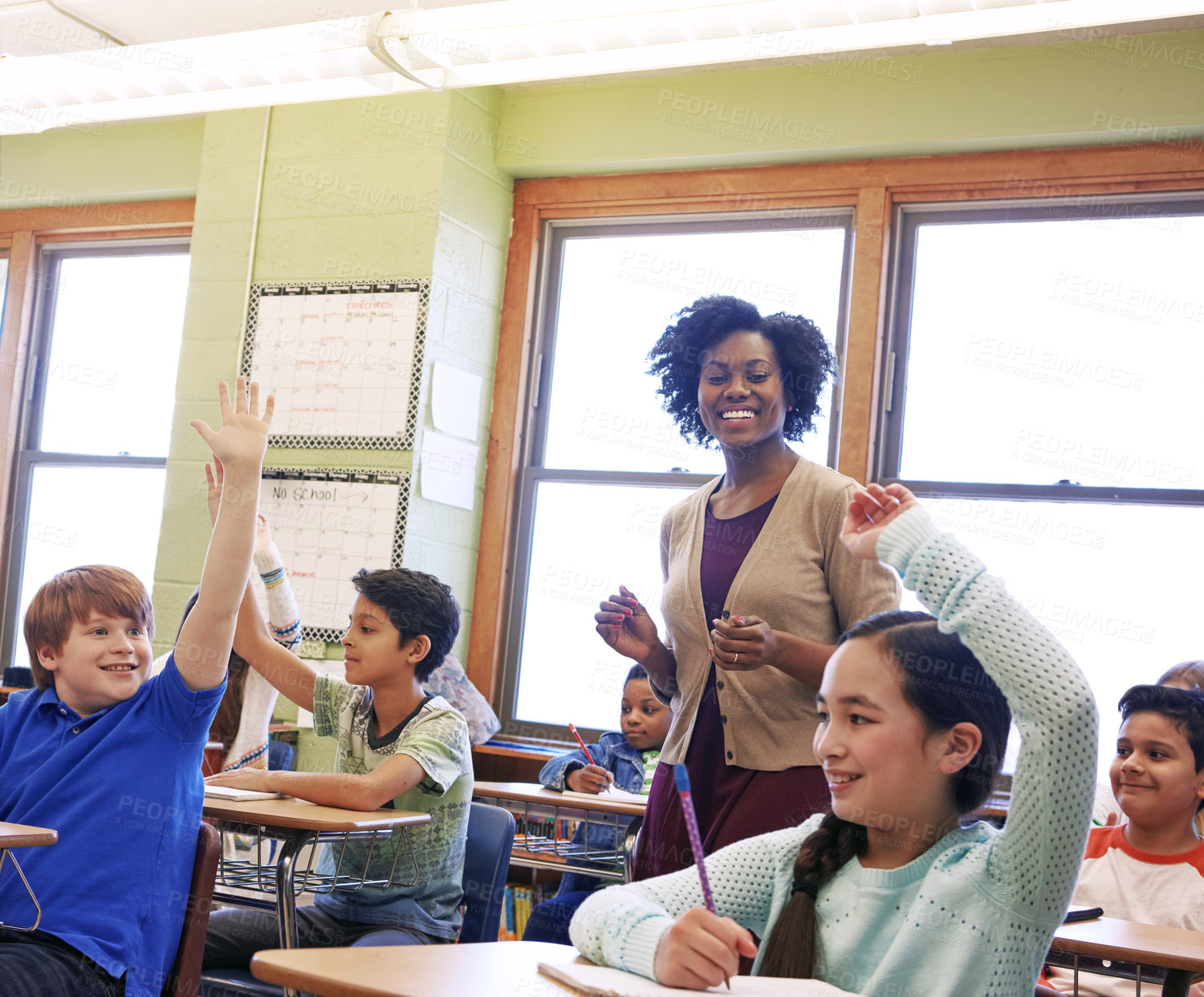 Buy stock photo Shot of a group of children raising their hands to answer their teacher's question