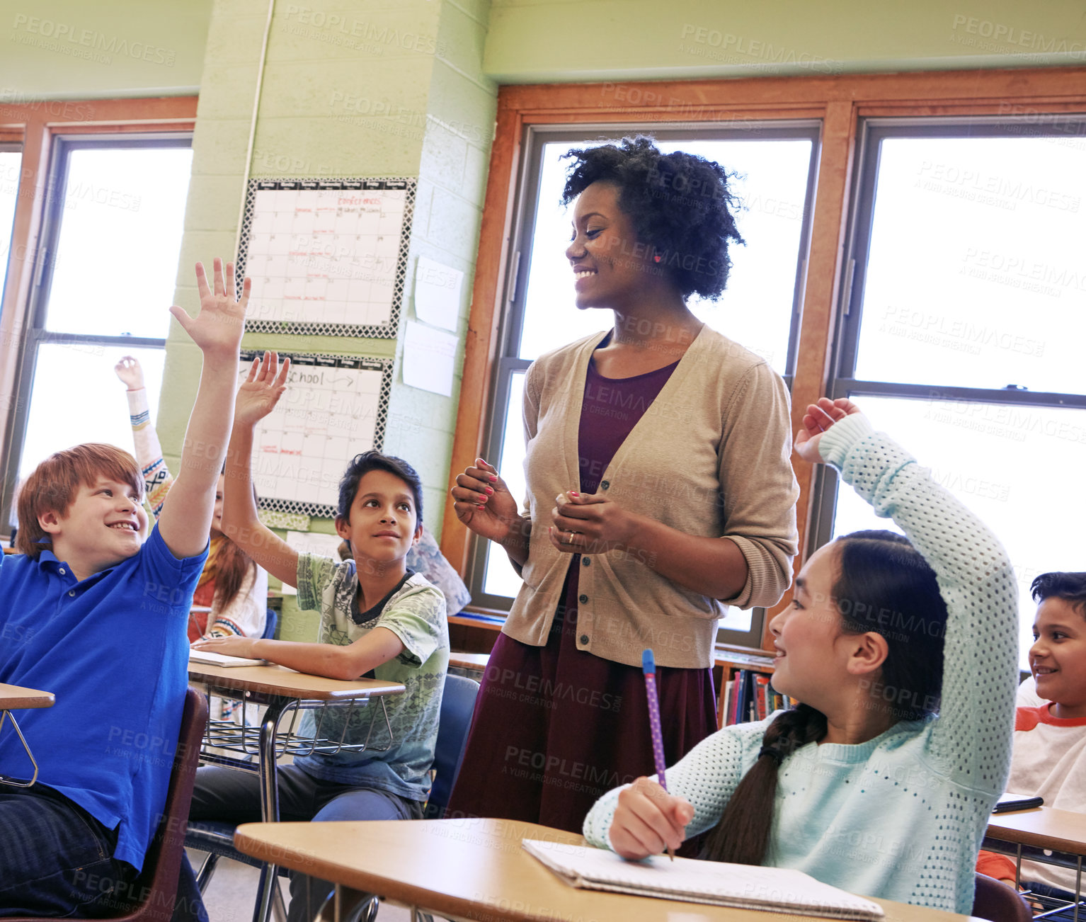 Buy stock photo Shot of a group of children raising their hands to answer their teacher's question