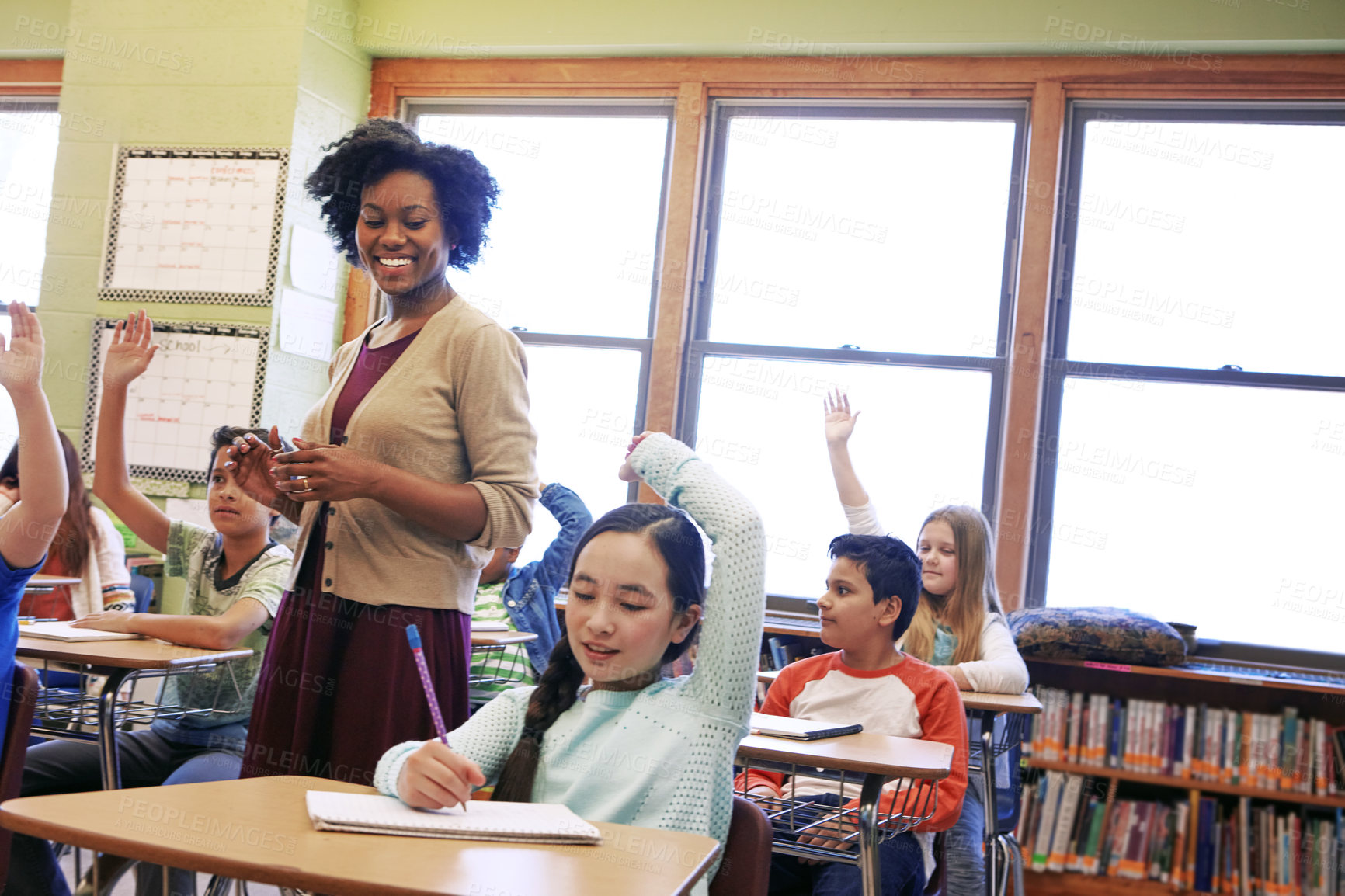 Buy stock photo Classroom, teacher and children with hands up, lesson and students with academic growth or education. Elementary school, woman and kids with answer, happy and cognitive development with knowledge