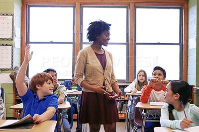 Buy stock photo Shot of a young boy raising his hand to answer his teacher's question