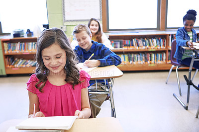 Buy stock photo Shot of a group of elementary school children sitting in a classroom