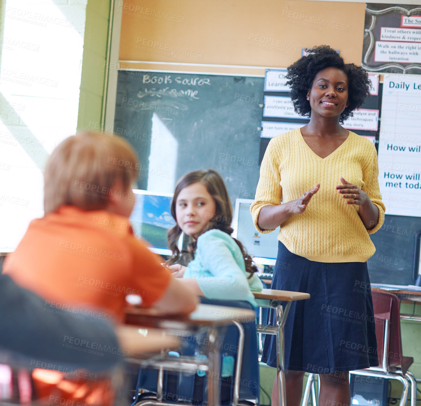 Buy stock photo Shot of a young teacher educating a group of elementary children