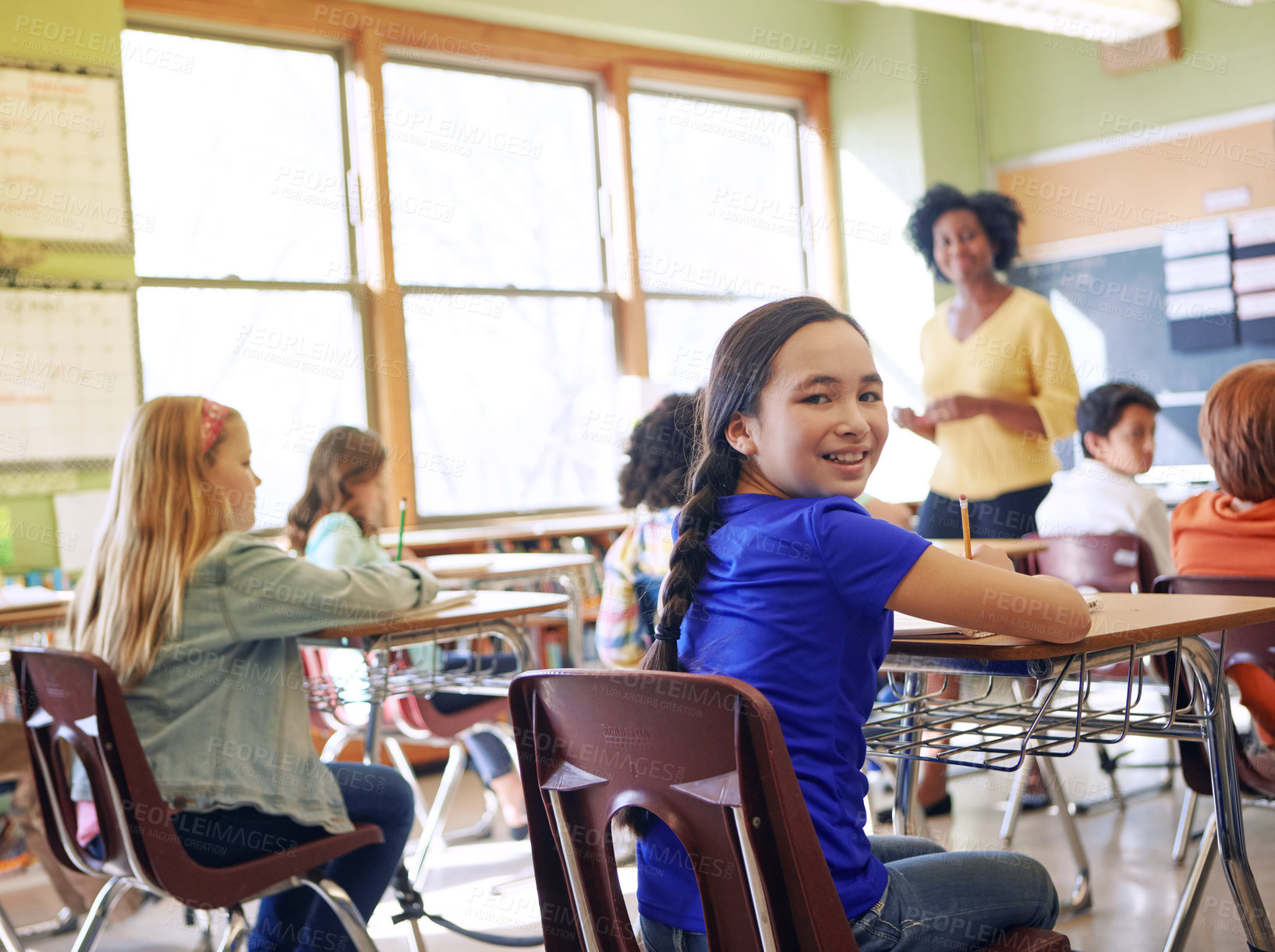 Buy stock photo Shot of a young girl sitting in class with her teacher and classmates blurred in the background