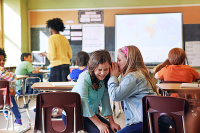 Buy stock photo Shot of a student whispering in a friend's ear