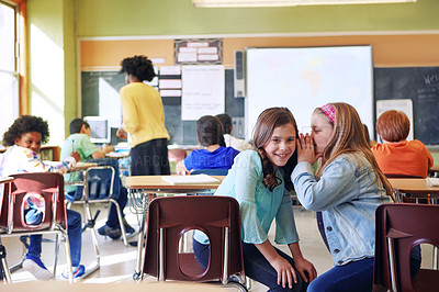 Buy stock photo Shot of a student whispering in a friend's ear