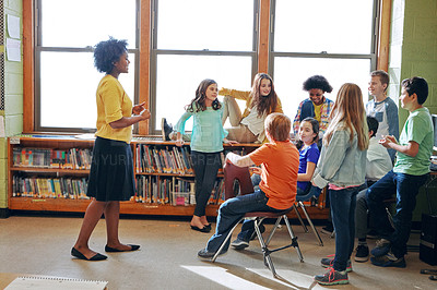 Buy stock photo Shot of a young teacher educating a group of elementary children