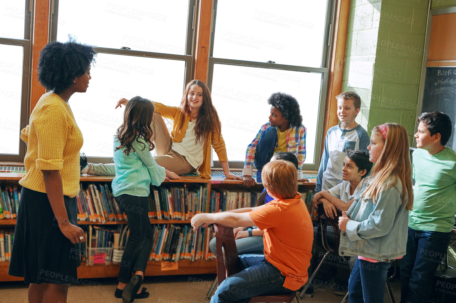 Buy stock photo Education library, teacher and children students in classroom of elementary school. Development, learning scholarship and group of kids talking, discussion and studying for knowledge with black woman