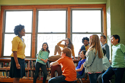 Buy stock photo Shot of a young teacher educating a group of elementary children