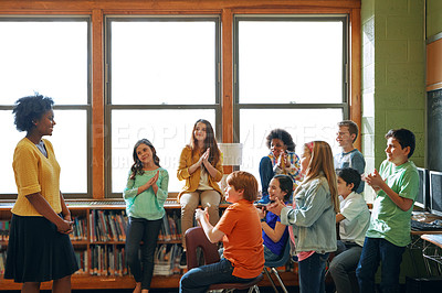 Buy stock photo Shot of a young teacher educating a group of elementary children