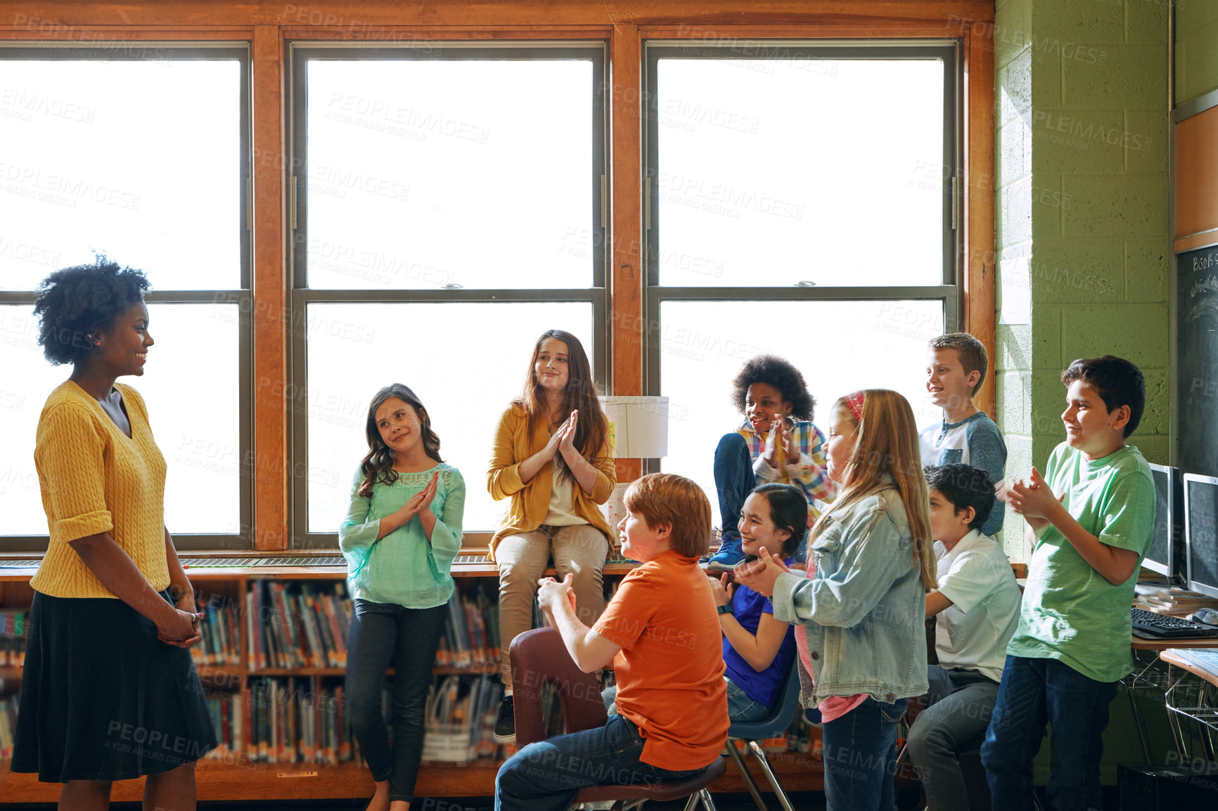 Buy stock photo Shot of a young teacher educating a group of elementary children