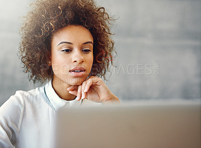 Buy stock photo Shot of a young woman working on a laptop at home