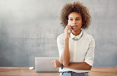 Buy stock photo Shot of a young woman talking on a cellphone in her office