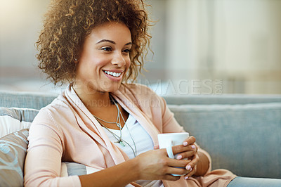 Buy stock photo Shot of a young woman relaxing with a warm beverage at home