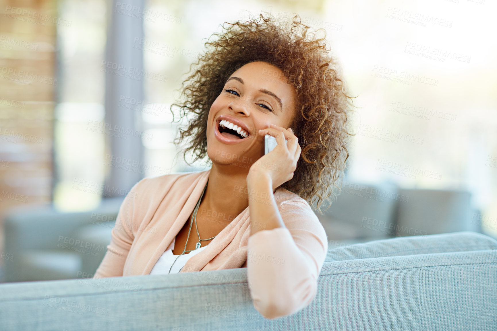 Buy stock photo Shot of a young woman talking on her phone on a relaxing day at home