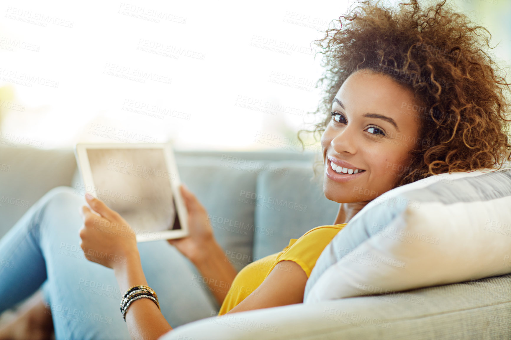Buy stock photo Portrait of a young woman using a digital tablet on a relaxing day at home