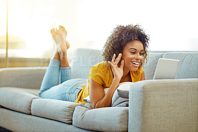 Buy stock photo Shot of a young woman video chatting on her tablet at home