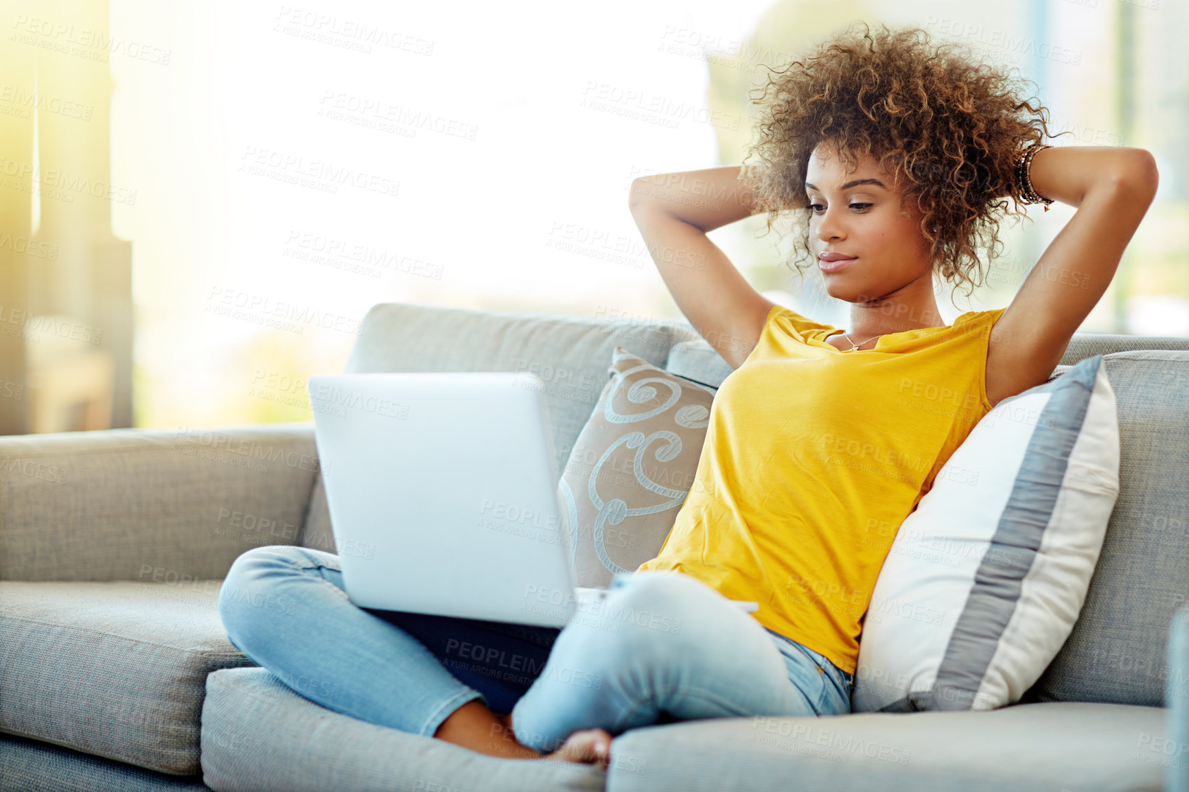 Buy stock photo Shot of a young woman using a laptop on a relaxing day at home