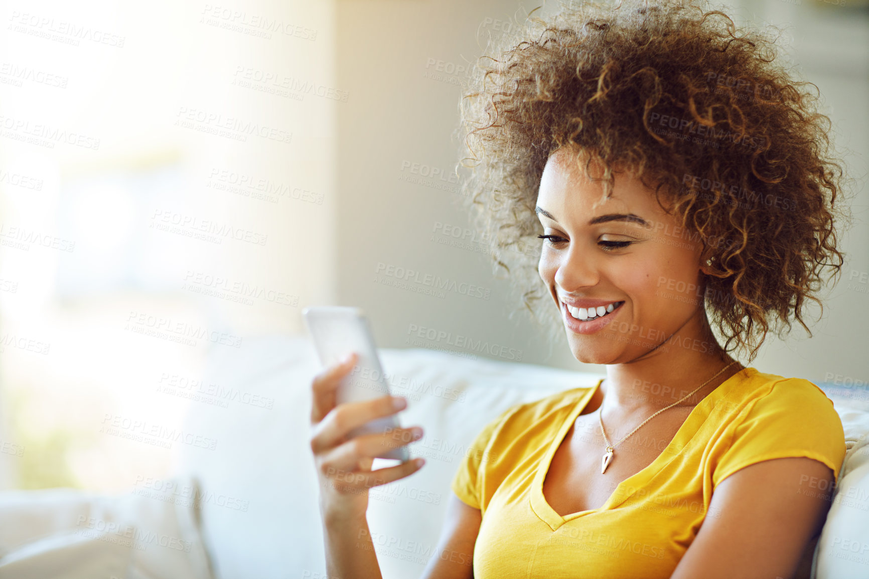 Buy stock photo Shot of a young woman using her phone on a relaxing day at home