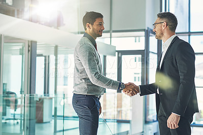 Buy stock photo Shot of two businessmen shaking hands together in an office