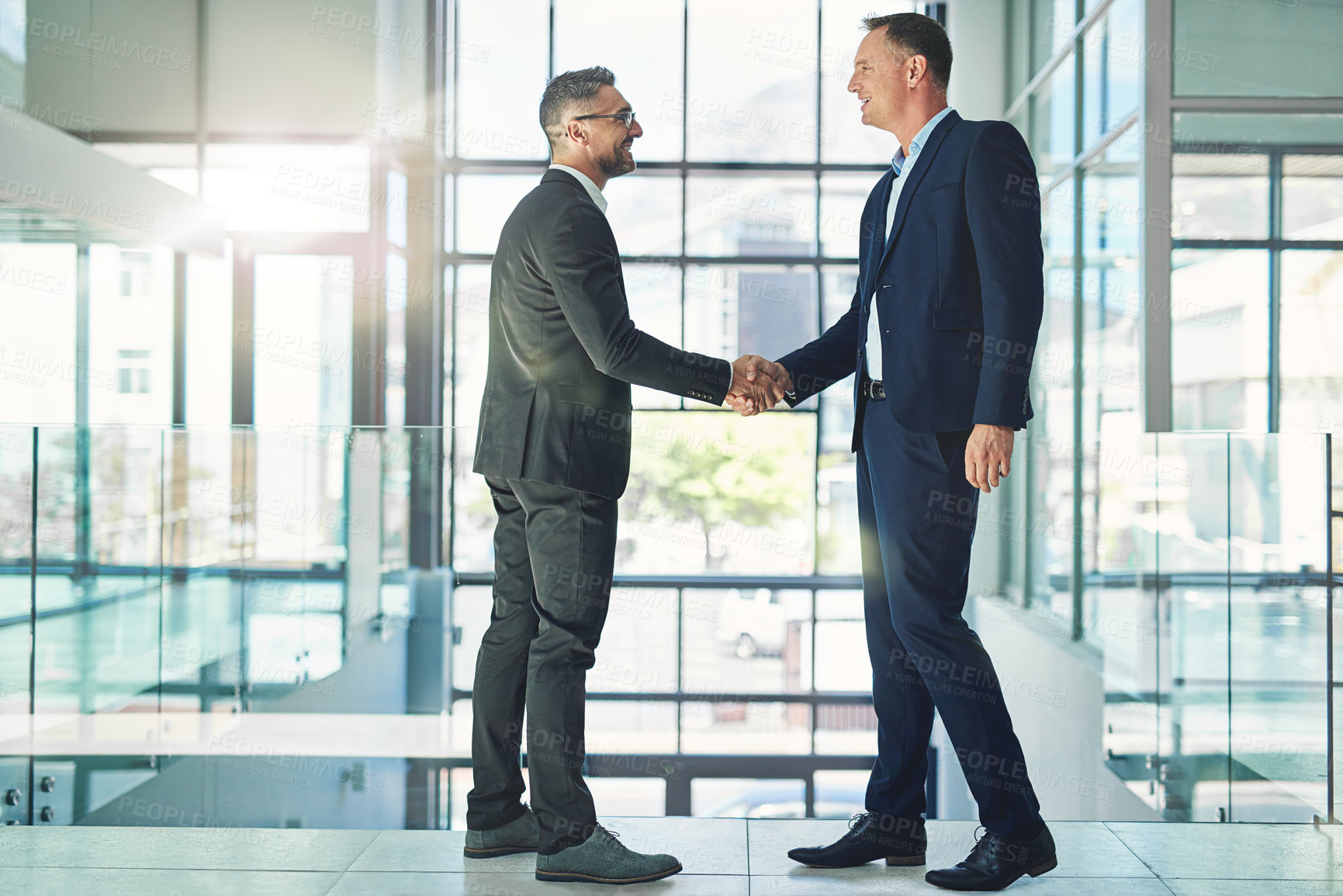 Buy stock photo Confident, smiling corporate businessmen exchange handshake in global trust merger meeting together at modern company. Professional executive colleagues in company trade development deal conference 