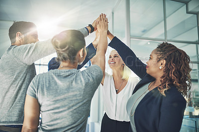 Buy stock photo Shot of a diverse group of coworkers high fiving together in an office