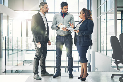 Buy stock photo Planning, talking and professional group of business people preparing for a meeting on a digital tablet in a modern office. Diverse team discussing creative plan and strategy for a proposal  