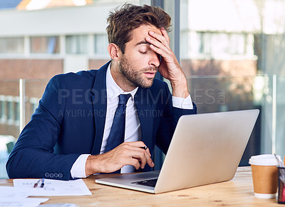 Buy stock photo Shot of a businessman looking exhausted while working on his laptop