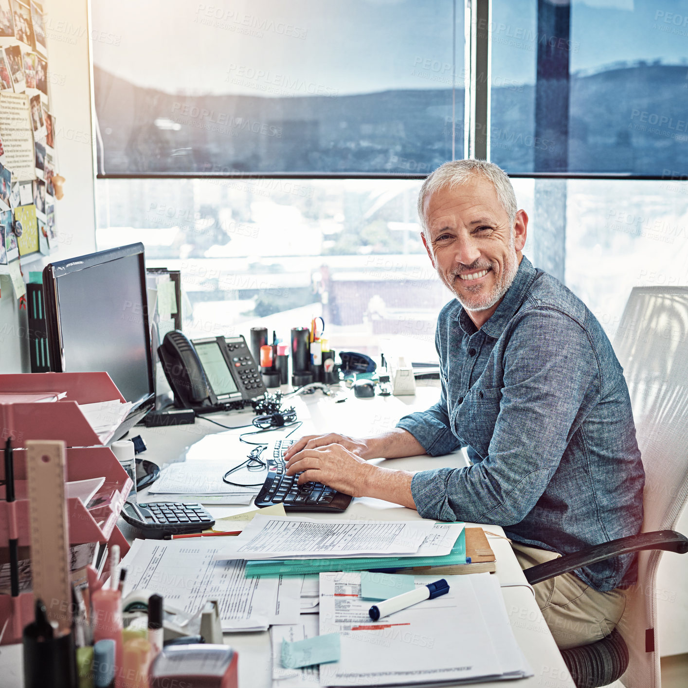 Buy stock photo Shot of a mature man at work on computer in an office