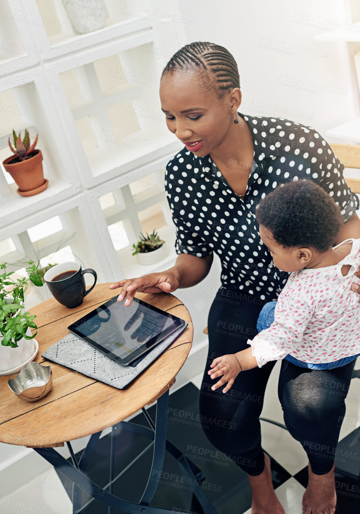 Buy stock photo Shot of a mother sitting with her baby girl and using a digital tablet