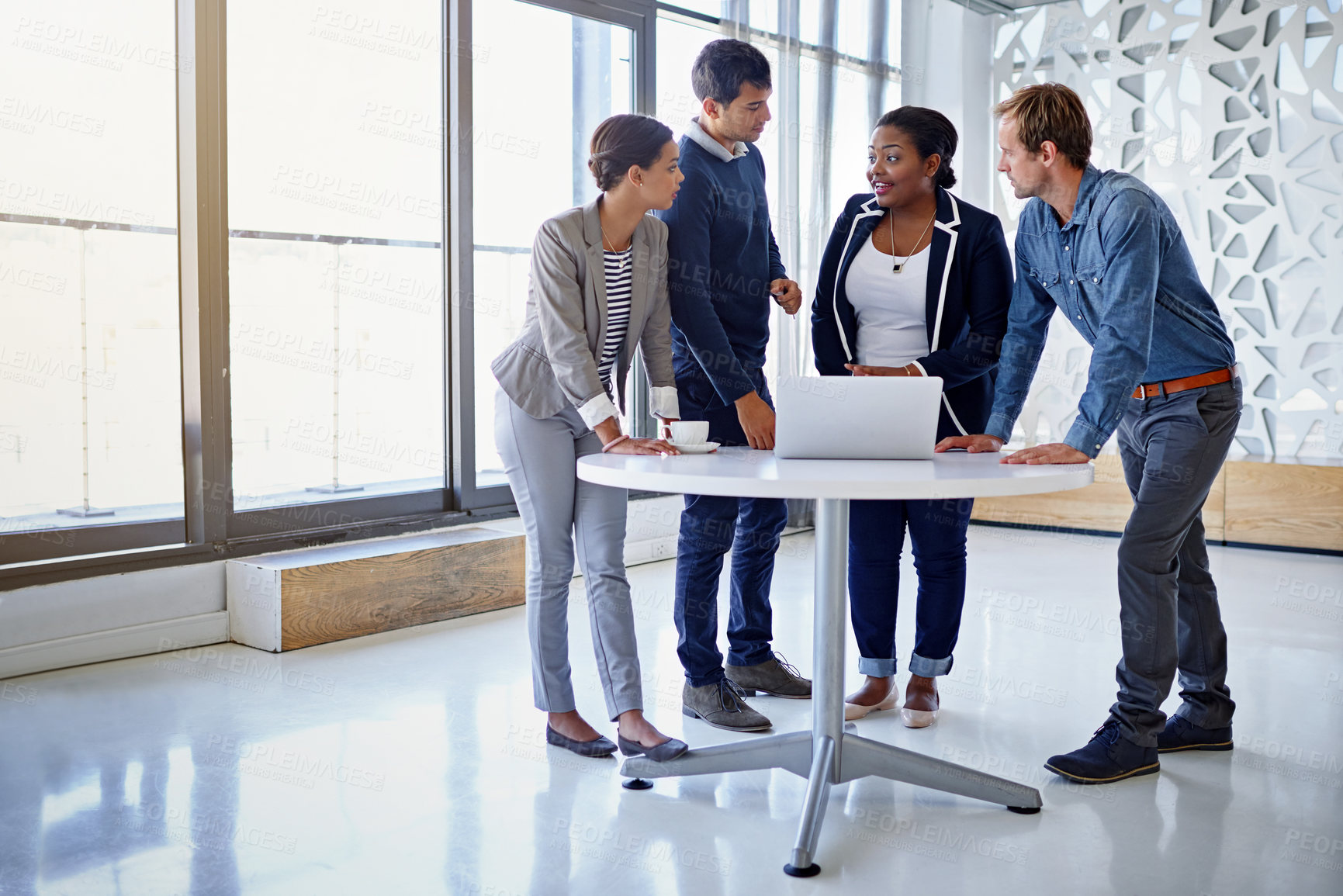 Buy stock photo Shot of a group of coworkers working together on a laptop in an office