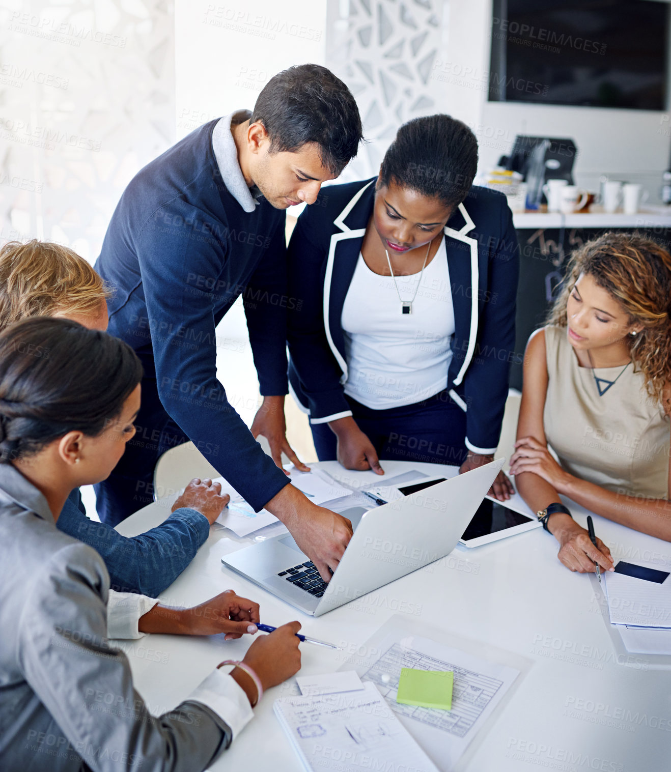 Buy stock photo Shot of a group of coworkers working together on a laptop in an office