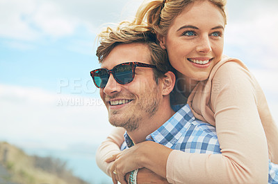 Buy stock photo Shot of a young man piggybacking his girlfriend
