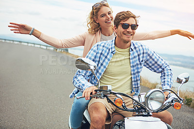 Buy stock photo Shot of a young couple out for a ride on a scooter