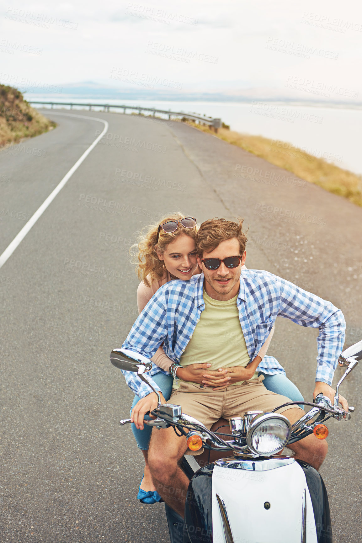 Buy stock photo Shot of a young couple out for a ride on a scooter