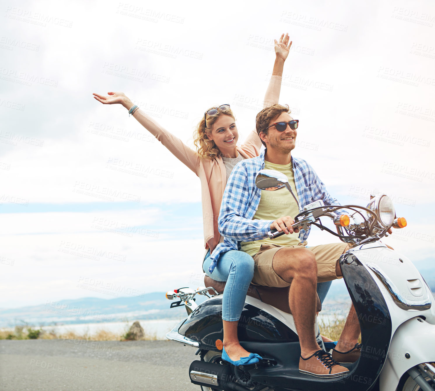 Buy stock photo Shot of a young couple out for a ride on a scooter