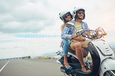 Buy stock photo Shot of a young couple out for a ride on a scooter