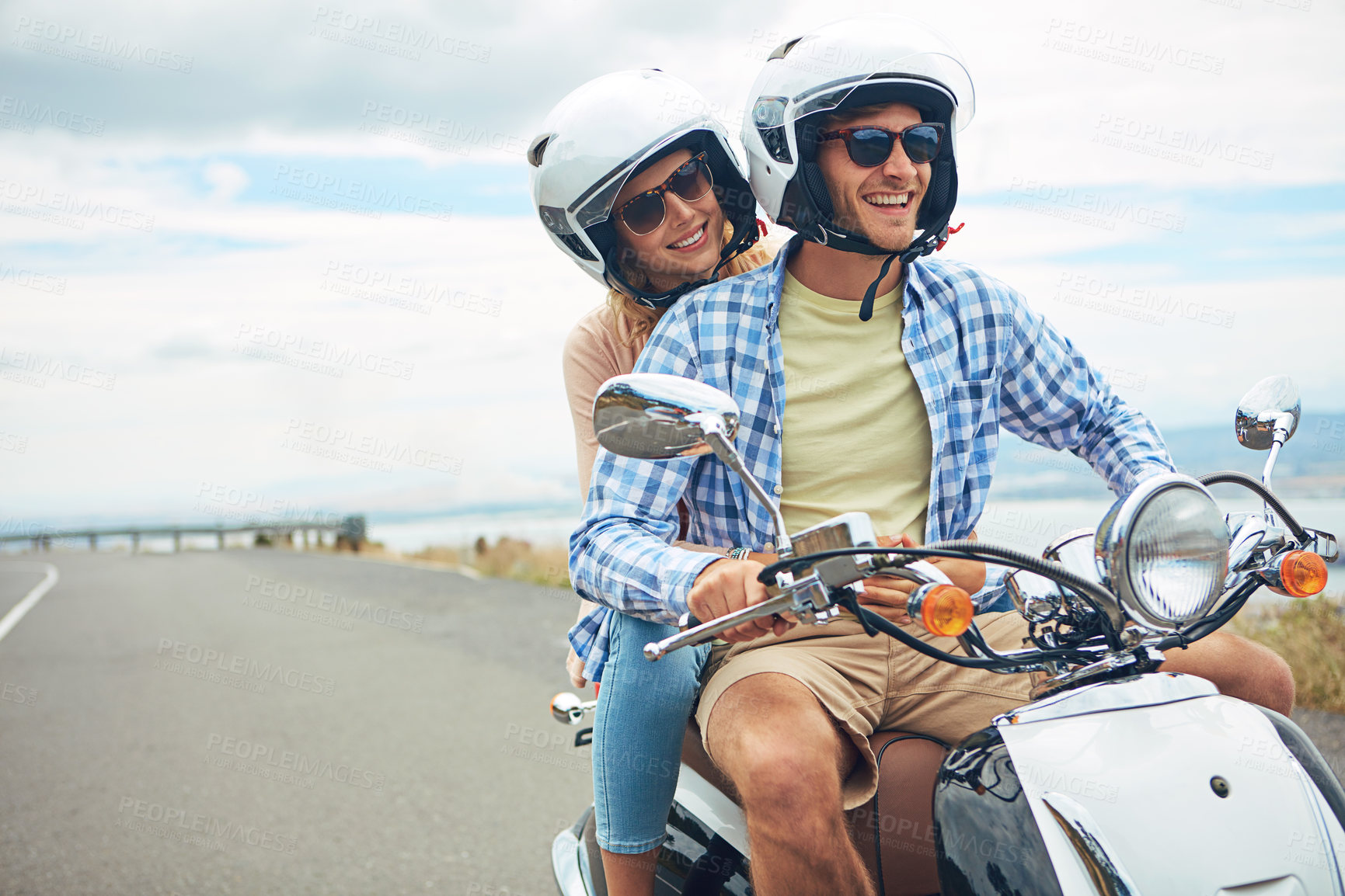 Buy stock photo Shot of a young couple out for a ride on a scooter