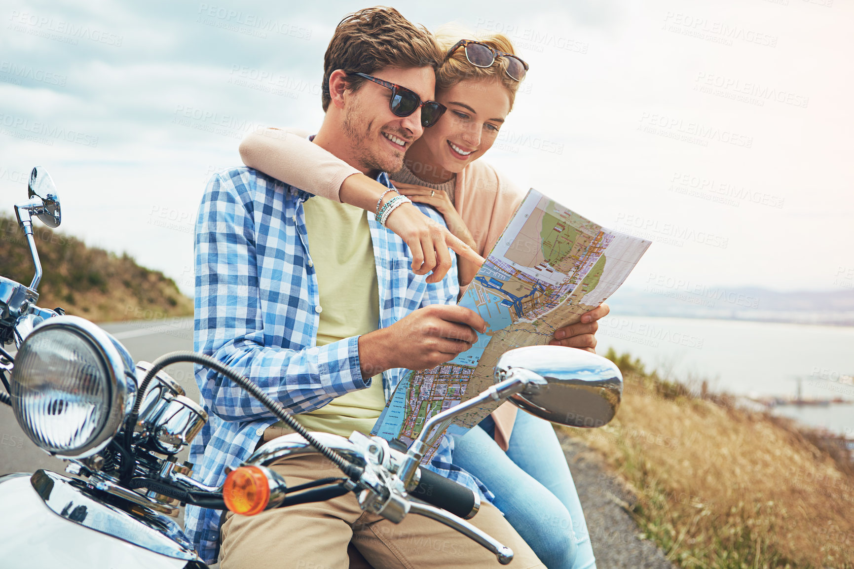 Buy stock photo Shot of a couple using a map while out on a road trip